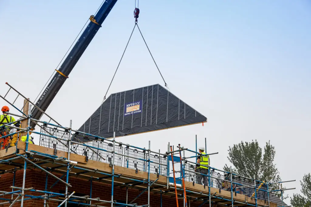 A spandrel panel being lowered into place ready to construct the NYTROOF, which is a panelised room in the roof system